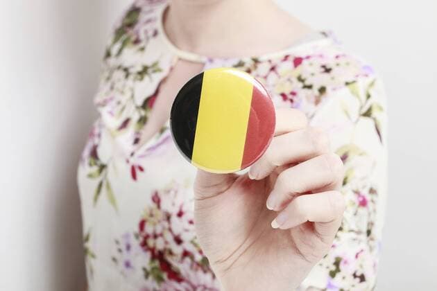 Flag of Germany printed on button badge, holding by woman in her beautiful hands.  BEW1D4136FA