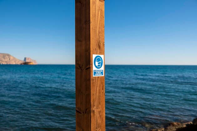 20 01 2021, Altea, Alicante, Spain, Pictogram of a head wearing a mask and the words Es obligatorio el uso de la mascarilla The use of the mask is compulsory indicate the Covid 19 hygiene rules at the beach