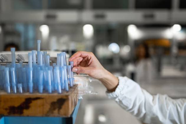 IMAGO Creative: Bildung, Wissenschaftserziehung Side view of crop anonymous specialist in white coat taking flask from stand while conducting medical research in lab, Model released Copyright: xCarlosxPintaux MR
