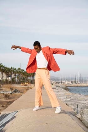 IMAGO Creative: Clickbait, Modetrends Young man with arms outstretched dancing while standing against sky model released Symbolfoto AFVF07890