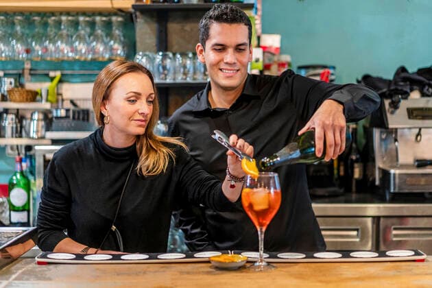 Female bartender preparing cocktail with male assistant model released Symbolfoto property released DLTSF01496