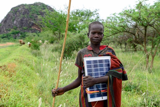 IMAGO Nature: Unsere Erde, Naturschutz, Indigene Völker Uganda, Karamoja, Karamojong tribe UGANDA, Karamoja, Kotido, karamojong pastoral tribe, young shepherd with grazing cattle carrying a solar panel to charge the mobile phone *** Karamojong Ethnie, junger Hirte mit Vieh beim Weiden, Junge mit Solarpanel zum Aufladen des Handy Kotido Karamoja Uganda