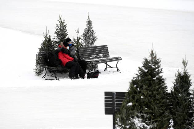 January 28, 2021, Ottawa, on, Canada: Skaters embrace on a bench at a rest stop on the Rideau Canal Skateway on its opening day in Ottawa, on Thursday, Jan. 28, 2021, in the midst of the COVID-19 pandemic. The Rideau Canal is a UNESCO World Heritage Site. Ottawa Canada  - ZUMAc35_ 20210128_zaf_c35_001 Copyright: xJustinxTangx