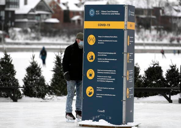 January 28, 2021, Ottawa, on, Canada: A skater reads a sign on COVID-19 measures on the Rideau Canal Skateway on its opening day in Ottawa, on Thursday, Jan. 28, 2021. The Rideau Canal is a UNESCO World Heritage Site. Ottawa Canada  - ZUMAc35_ 20210128_zaf_c35_003 Copyright: xJustinxTangx