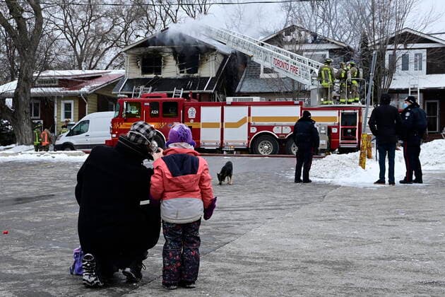 January 29, 2021, Toronto, on, Canada: Bystanders look on a firefighters work to put out a house fire in Toronto, Friday, Jan.29, 2021. Fire ripped through an east-end Toronto home early Friday killing four people and injuring several others. Toronto Canada  - ZUMAc35_ 20210129_zaf_c35_013 Copyright: xThexCanadianxPressx