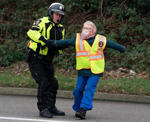 January 29, 2021, Vancouver, BC, Canada: A member of the Vancouver Police Department stops a member of the Extinction Rebellion from crossing the blocked highway as the group blocked the entrance to the Port of Vancouver, Friday, January 29, 2021. The protesters planned the march and blockade as a part of their anti-pipeline campaign. Vancouver Canada  - ZUMAc35_ 20210129_zaf_c35_071 Copyright: xJonathanxHaywardx