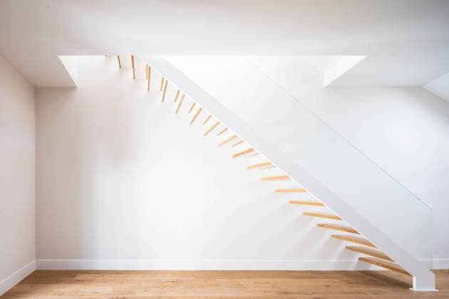 Creative Highlights World Wooden staircase above parquet near white wall with shadow in contemporary building in daylight Copyright: xJavierxBravox Model Released