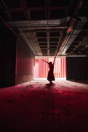 Anonymous female dancer in dress dancing with raised arms on theater stage during rehearsal, Model released Copyright: xRubenxSotox MR