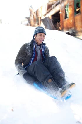 IMAGO Creative: Countdown bis Weihnachten, Nach Hause reisen Man sliding down snowy hill in sled Prineville, OR, United States CR_ISKO210119H-349303-01 ,model released, Symbolfoto