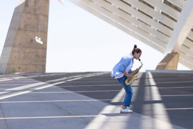 Woman with ponytail playing a saxophone while standing outdoors Barcelona, CT, Spain CR_RAFE210119-583512-01 ,model released, Symbolfoto