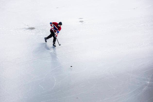 IMAGO Creative, Winter, Winterspaß, Eishockey #2 Hockey player skating and shooting puck on ice playing pond hockey Canada, British Columbia, Pemberton CR_PSFZ210201-623656-01 ,model released, Symbolfoto