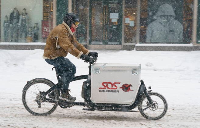 February 2, 2021, Montreal, PQ, Canada: A courier rides down Saint-Catherine street during a snowstorm in Montreal, on Tuesday, February 2, 2021. Quebec Premier Francois Legault is expected to announce a loosening of some restrictions including the reopening of non-essential businesses province-wide. Montreal Canada  - ZUMAc35_ 20210202_zaf_c35_028 Copyright: xPaulxChiassonx