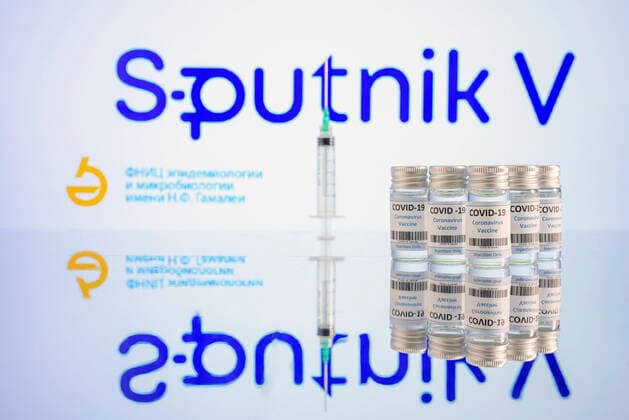 Vaccine doses and syringes stand on a table in front of the logo of the vaccine Sputnik V of the Russian Gamaleja Institute of Epidemiology and Microbiology Topic Image, Symbol Image Foto:xD.xAnoraganingrumx xFuturexImage