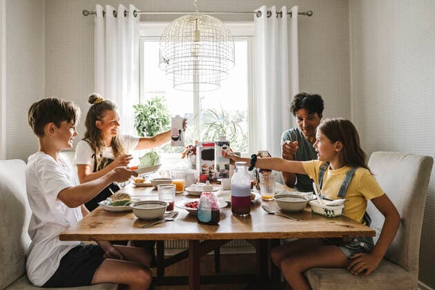 Parents having breakfast with children over table at home Sweden, Gothenburg, model released, property released Copyright: xMaskotx , MA83735