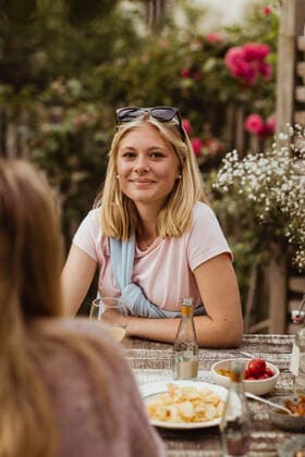 IMAGO Creative: Landleben - Essen IMAGO Creative: Landleben - Alfresco, Draußen Smiling teenage girl sitting with food at table during dinner party Sweden, Gothenburg, model released, property released Copyright: xMaskotx , MA83779