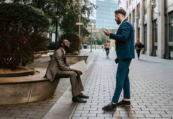 Businessman discussing with male colleague on footpath in city Germany, Berlin, model released Copyright: xMaskotx , MA84237