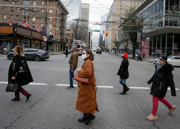 (210205) -- VANCOUVER, Feb. 5, 2021 -- People wearing face masks cross a street in downtown Vancouver, British Columbia, Canada, on Feb. 5, 2021. The unemployment rate in Canada rose by 0.6 percentage point to 9.4 percent in January, the highest rate since August 2020, said official Statistics Canada on Friday. (Photo by Xinhua) CANADA-VANCOUVER-UNEMPLOYMENT RATE-RISING LiangxSen 
