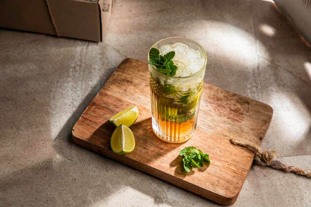 From above of refreshing cold alcoholic mojito with ice mint leaves and cut lime on wooden board Copyright: xPabloxGarciax Model Released