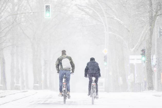 Zwei Personen fahren mit dem Rad im Schneesturm entlang einer Allee in Berlin, 07.02.2021. Berlin Deutschland *** Two people ride their bikes in a snowstorm along an avenue in Berlin, 07 02 2021 Berlin Germany Copyright: xFlorianxGaertner photothek.dex
