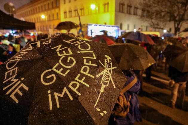 Demonstration against Corona requirements 07 02 2021 MUNICH Participants with umbrellas at a rally against Corona requirements on Geschwister Scholl Platz in front of Munichs Ludwig Maximilians University in downtown Munich On the umbrella it says PLANDEMY, AGAINST VACCINATION and THINK FOR YOURSELF Munich Bavaria Germany