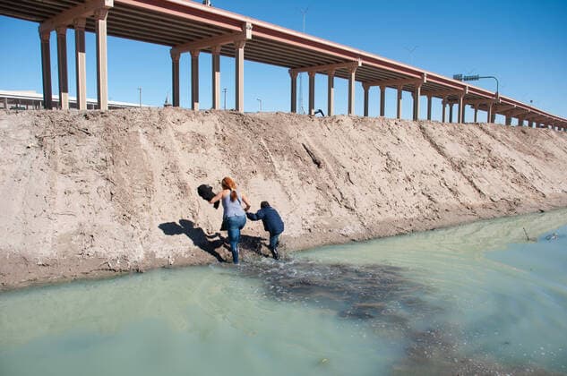 Mexico: New crisis migration A Central American woman and her son cross the Rio Grande to surrender to the border patrol at the Texas United States crossing, moments later another family crossed with the intention of requesting political asylum in the United States. Juarez Chihuahua Mexico Copyright: DavidxPeinado