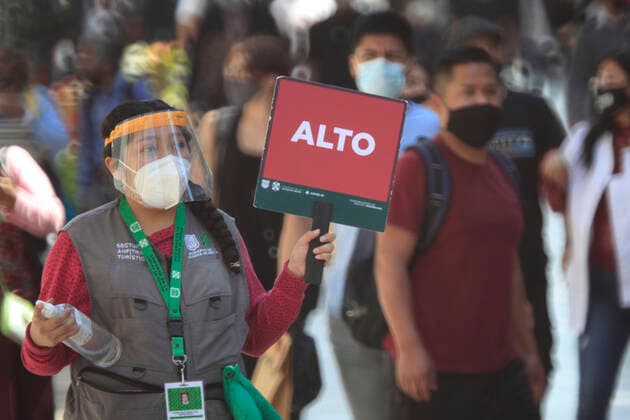 February 9, 2021, Mexico City, Mexico City, Mexico: A officer holds a sign to people follow the rules to prevent agglomerations. The Mexican Government allowed the reopening of stores, some shops make outside sell to prevent crowd of people, as an attempt to prevent spread of the Virus February 9, 2021 in Mexico City, Mexico Mexico City Mexico - ZUMAe321 20210209_zia_e321_029 Copyright: xAngelxMoralesxRizox