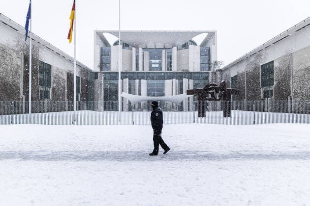 IMAGO Creative, Jahreszeit Winter in der Stadt Ein Polizist zeichnet sich ab vor dem Bundeskanzleramt vor dem Bund-Laender-Treffen zum weiteren Vorgehen der Corona-Beschraenkungen, aufgenommen in Berlin, 10.02.2021. Berlin Deutschland *** A police officer stands out in front of the Chancellors Office before the federal Laender meeting on further action of the Corona restrictions, photographed in Berlin, 10 02 2021 Berlin Germany Copyright: xFlorianxGaertner photothek.dex