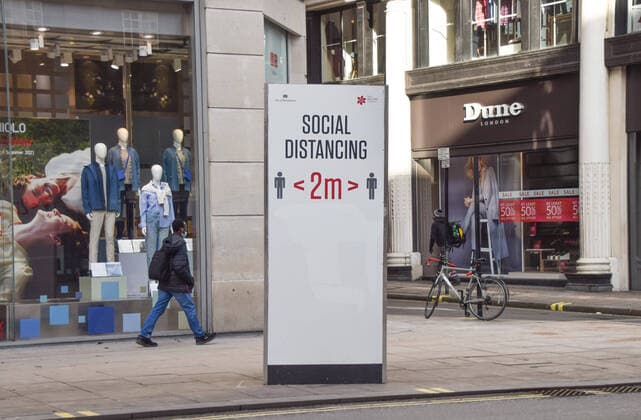 February 10, 2021, London, United Kingdom: A man wearing a protective face mask walks past a social distancing sign on Oxford Street, London..Most businesses remain shut in the UK as the nation continues to battle with the coronavirus pandemic. London United Kingdom - ZUMAs197 20210210_zaa_s197_134 Copyright: xVukxValcicx