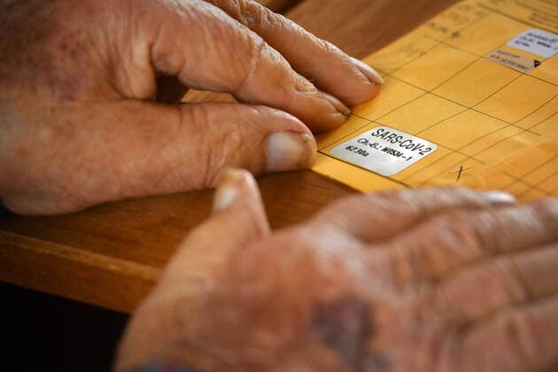 Wrinkled hands of an old man 92 years old lying on his vaccination card after vaccination,Corona vaccination against SARS CoV 2
