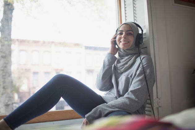 Muslim woman wearing a hijab listening to music model release HEX17009_TP__7335 Copyright: xTOBIASxPRASSEx