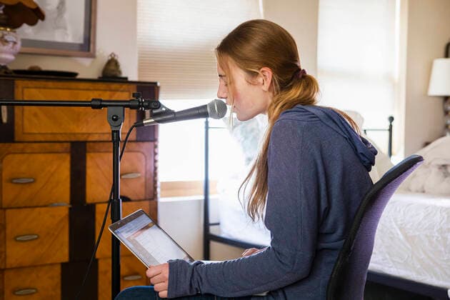 Teenage girl singing into a microphone in her bedroom United States,Teenage girl singing into a microphone in her bedroom  Teenage girl singing into a microphone in her bedroom