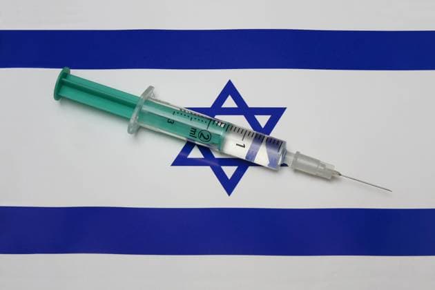 Syringe on a country flag Syringe on a country flag, 10 02 2021, Borkwalde, Brandenburg, A syringe with a vaccine lies on the country flag of Israel