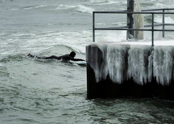 February 12, 2021, Toronto, on, Canada: A man surfs in the frigid ice cold waters of Lake Ontario during the COVID-19 pandemic in Toronto on Friday, February 12, 2021. Toronto Canada  - ZUMAc35_ 20210212_zaf_c35_034 Copyright: xNathanxDenettex