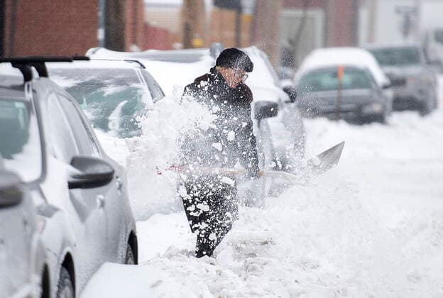 February 16, 2021, Montreal, PQ, Canada: A woman shovels snow from around her car during a snowstorm in Montreal, Tuesday, February 16, 2021. Montreal Canada  - ZUMAc35_ 20210216_zaf_c35_019 Copyright: xGrahamxHughesx