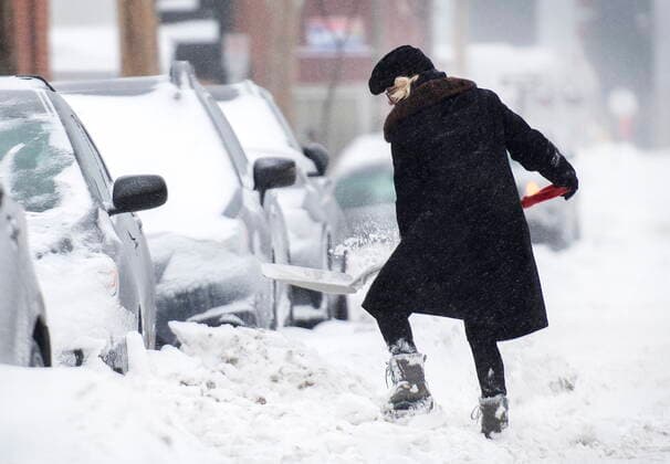 February 16, 2021, Montreal, PQ, Canada: A woman shovels snow from around her car during a snowstorm in Montreal, Tuesday, February 16, 2021. Montreal Canada  - ZUMAc35_ 20210216_zaf_c35_028 Copyright: xGrahamxHughesx
