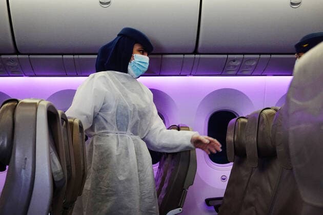 17 02 2021, Frankfurt am Main, Hessen, GER Flight attendant walks through the empty seats in an airplane cabin with mouth nose protection d