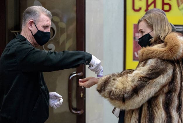 IRKUTSK, RUSSIA - FEBRUARY 19, 2021: A woman has her body temperature measured at an entrance to Zagursky Music Theatre that hosts the Stars on Baikal International Music Festival. The festival is the first large-scale cultural event in the region since the lifting of COVID-19 restrictions. Alexei Kushnirenko TASS  TS0F7439