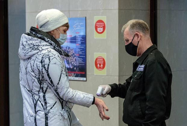 IRKUTSK, RUSSIA - FEBRUARY 19, 2021: A woman has her body temperature measured at an entrance to Zagursky Music Theatre that hosts the Stars on Baikal International Music Festival. The festival is the first large-scale cultural event in the region since the lifting of COVID-19 restrictions. Alexei Kushnirenko TASS  TS0F743A