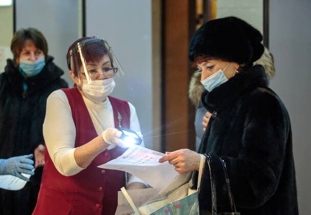 IRKUTSK, RUSSIA - FEBRUARY 19, 2021: Scanning tickets at an entrance to Zagursky Music Theatre that hosts the Stars on Baikal International Music Festival. The festival is the first large-scale cultural event in the region since the lifting of COVID-19 restrictions. Alexei Kushnirenko TASS  TS0F7444