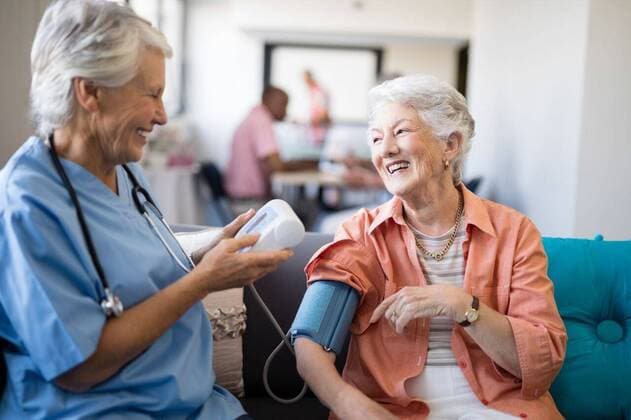 Smiling senior woman talking to female doctor Smiling senior woman talking to female doctor during blood pressure check up at nursing home, model released, , property released, Cape Town, South Africa, 2017-04-27T23:00:00.000Z, 1041871.jpg, retirement, golden years, retired, casual clothing, retirement community, nursing home, geriatrics, lifestyle, assisted living, healthcare and medicine, friendship, sitting, doctor, female doctor, stethoscope, practitioner, lab coat, specialist, healthcare, health service, expertise, profession, holding, assistance, blood pressure gauge, nurse, healthcare worker, patient, medical exam, care, examining, a helping hand, professional occupation, talking, sofa, couch, sitting room, smiling, happy 70s, Senio