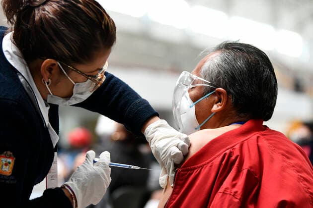 (210223) -- ECATEPEC, Feb. 23, 2021 -- A medical worker inoculates a citizen with a COVID-19 vaccine developed by Chinese pharmaceutical company Sinovac at a vaccination site in Ecatepec, Mexico, Feb. 22, 2021. Mexican health authorities on Monday began to vaccinate older adults with a COVID-19 vaccine developed by Chinese pharmaceutical company Sinovac, after a shipment of doses arrived on Saturday. Mexico s government designated the first shipment of the Sinovac vaccine to arrive in Ecatepec, a city in central State of Mexico that lies on the outskirts of the capital Mexico City. Early in the day, brigades of healthcare workers began to administer the vaccine to hundreds of residents aged 60 and over who went to the Las Americas 