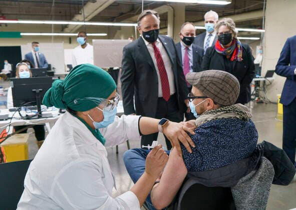 February 23, 2021, Montreal, PQ, Canada: Quebec Premier Francois Legault watches a man get his COVID-19 vaccine at a clinic in Montreal s Olympic Stadium on Tuesday, February 23, 2021. Montreal Canada  - ZUMAc35_ 20210223_zaf_c35_047 Copyright: xPaulxChiassonx