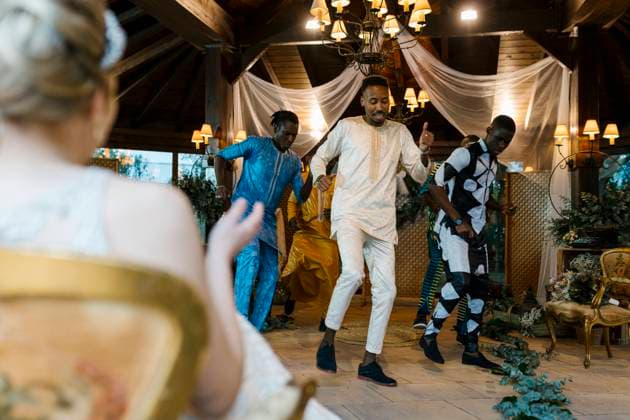 Bridge looking at groom dancing with friend in wedding at banquet model released Symbolfoto property released EGAF01680