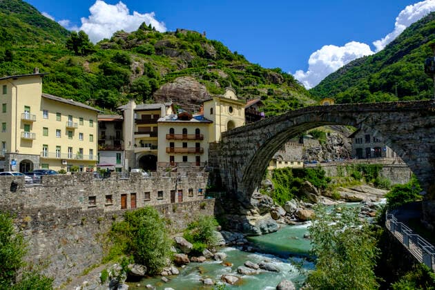 Italy, Pont-Saint-Martin, Town in Aosta Valley with Roman arch bridge stretching over river Lys in foreground LBF03362