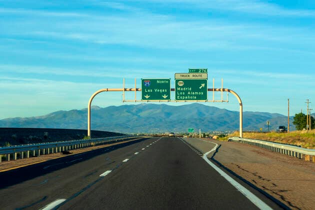 Road sign on highway against blue sky NDF01217