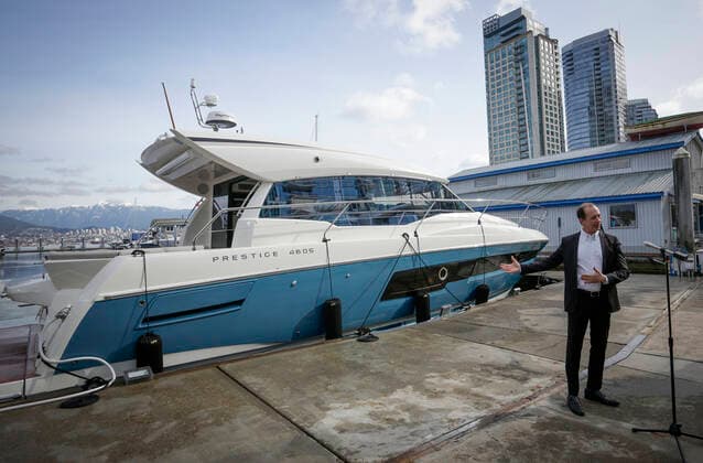 (210224) -- VANCOUVER, Feb. 24, 2021 -- A show organizer introduces a boat for display during the 2021 Vancouver International Boat Show, at a harbour in Vancouver, British Columbia, Canada, Feb. 24, 2021. The Vancouver International Boat Show which goes virtual this year due to the COVID-19 pandemic, kicked off on Wednesday, showcasing hundreds of new boats, products and accessories online. (Photo by Xinhua) CANADA-VANCOUVER-INTERNATIONAL BOAT SHOW LiangxSen