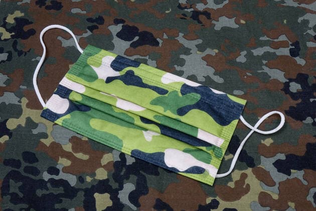 mouth mask and federal armed forces mouth mask and federal armed forces, 24 02 2021, Borkwalde, Brandenburg, A mouth mask lies on a camouflage material