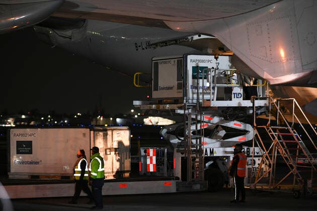(210228) -- MEXICO CITY, Feb. 28, 2021 -- Staff members unload temperature-controlled cargo containers with COVID-19 vaccines from Chinese company Sinovac at Mexico International Airport in Mexico City, Mexico, Feb. 27, 2021. The second shipment of COVID-19 vaccines from Chinese company Sinovac arrived in Mexico City on Saturday. ) MEXICO-MEXICO CITY-CHINA-SINOVAC-VACCINE-ARRIVAL XinxYuewei 