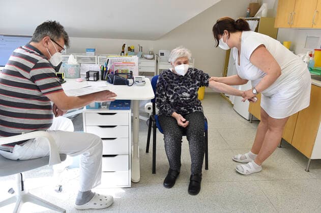Doctor Jiri Bartos, left, and an elderly woman, center, who receives a vaccine against the covid-19, at the surgery office in Moravska Nova Ves in Breclav region, Czech Republic, March 1, 2021. (CTKxPhoto VaclavxSalek) CTKPhotoP202103010743901  sal 05
