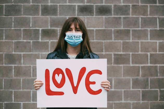 IMAGO Creative: Tag der Menschenrechte am 10. Dezember Young female protestor with love poster against wall during pandemic Sweden, Stockholm, model released Copyright: xMaskotx , MA84443